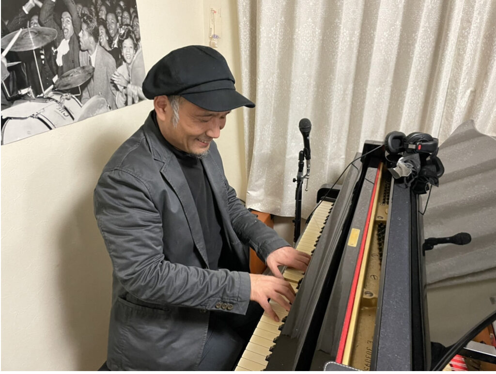 大阪・岸和田のジャズピアノ教室「Music Space サヴァサヴァ」で、初心者にも優しく笑顔でレッスンを行う講師の演奏風景。グランドピアノを使用。